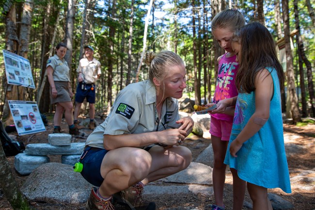 Person talking to two children near a portal information station