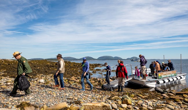 Park ranger leads group off tour boat onto an island