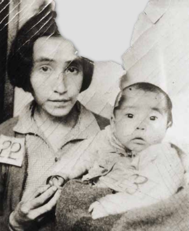 a woman holding a baby with numbers pinned to their shirts.