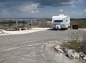 Trailer, picnic table, and ramada at Governors Landing Campground.