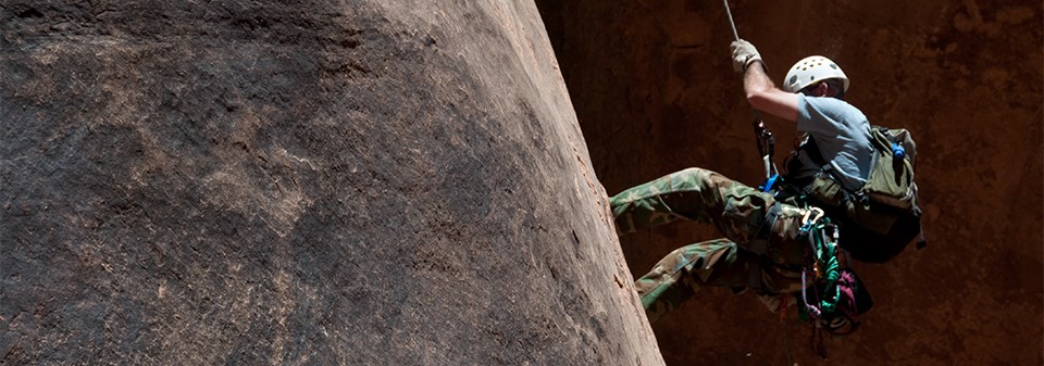 Rappelling into a canyon in Arches