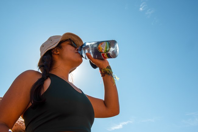 A visitor drinks water on a hot day