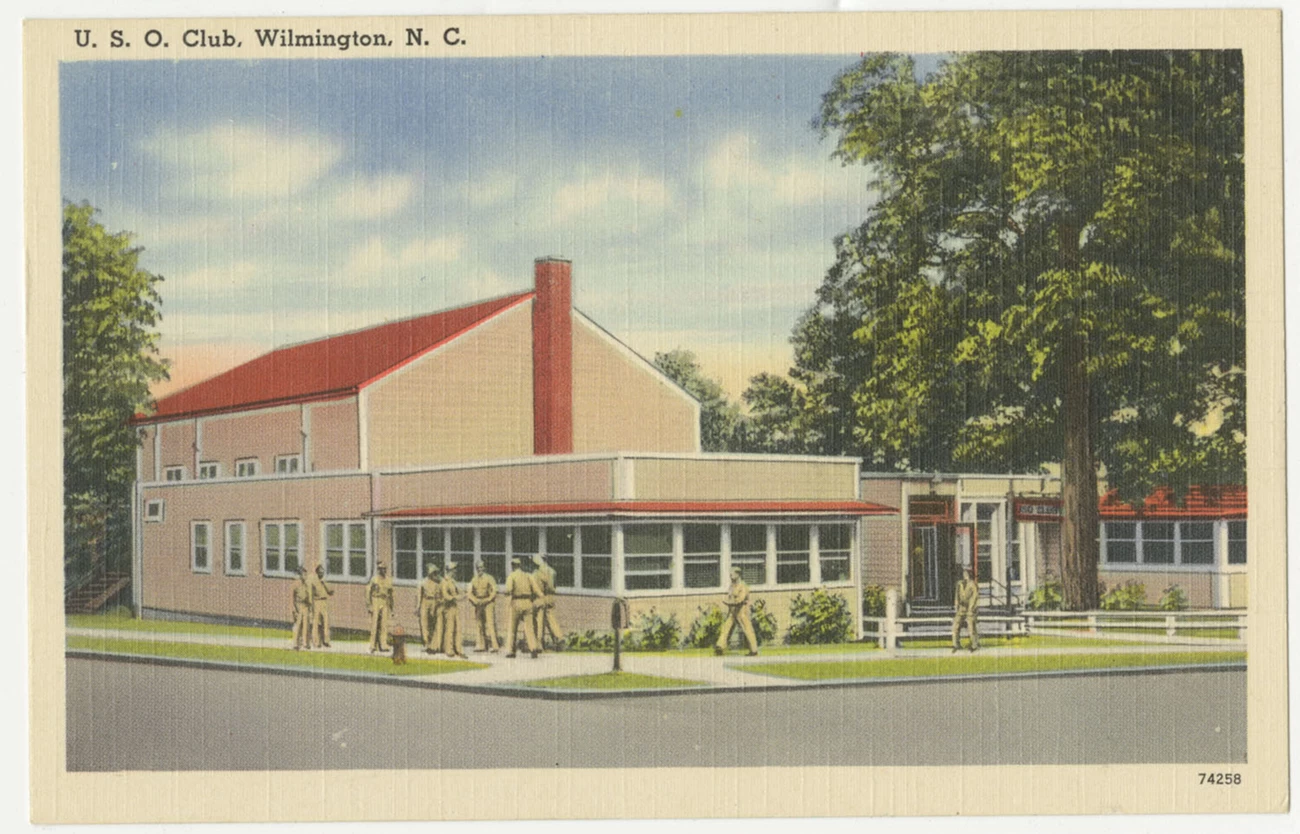 Postcard of the U.S.O. Club Postcard of the U.S.O. Club showing the side profile of the building and a tree next to the building