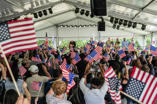 2025.06.12_BOST_Naturalization-006 crowd of people inside an event tent waving US flags