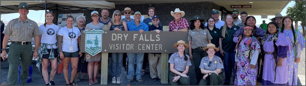 Group of people posing with sign