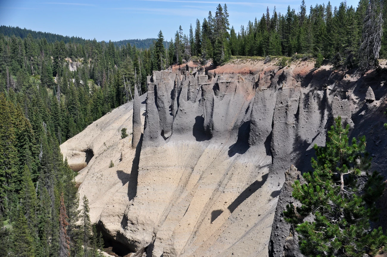 39431051110_8ebb0276cb_o Photo of layered rock outcrop with unusual erosional features surrounded by forested hills