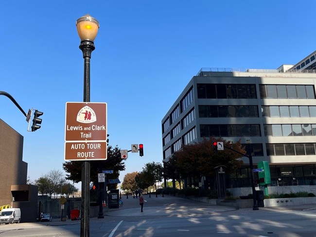 A sign reading Lewis and Clark Trail Auto Tour Route in an urban seting