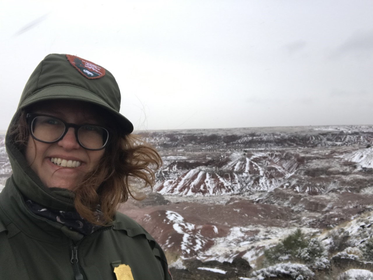 a ranger in uniform standing in a snow-covered desert