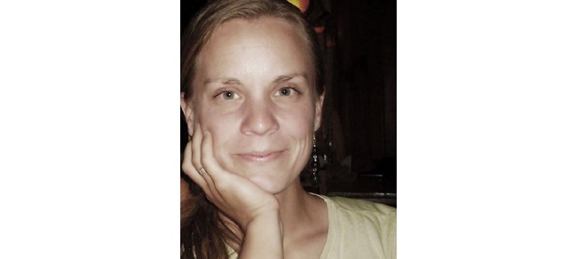 Headshot of Burch resting her chin on her hand, looking into the camera.