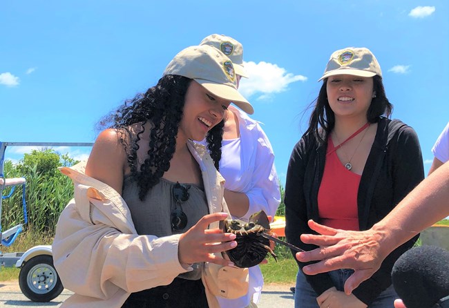 Valeria encounters a horseshoe crab for the first time in her life as Yolanda looks on.