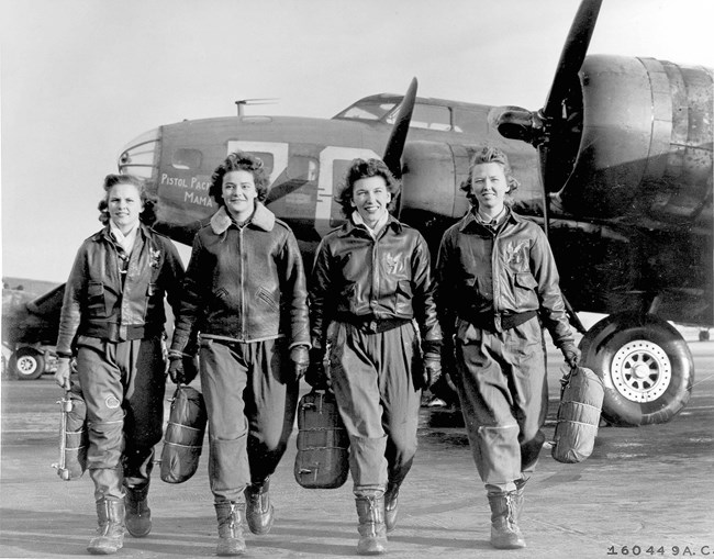 Frances Green, Margaret (Peg) Kirchner, Ann Waldner and Blanche Osborn leaving their plane, "Pistol Packin' Mama." US Air Force photo, public domain. Four white women in leather jackets walk toward the camera away from a plane