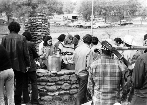 Union members served food to crowd outdoors. Musicians in cowboy hats play guitar.