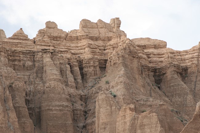 layered badlands buttes reach into a cloudy sky above