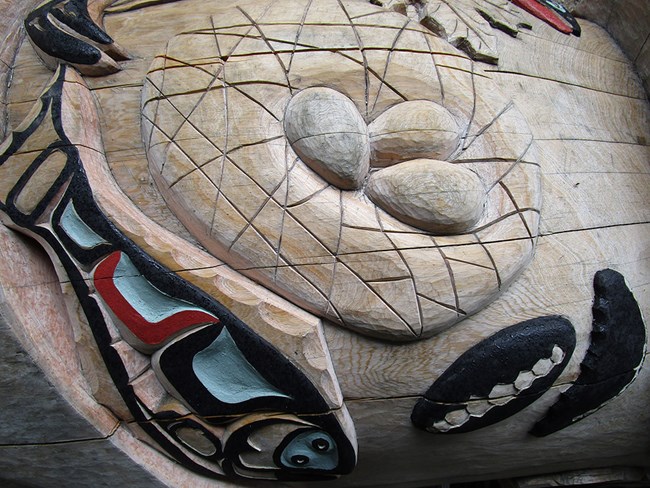 IMG_1181_NPSMBMossweb A section of a totem pole carving showing gull eggs in a nest.