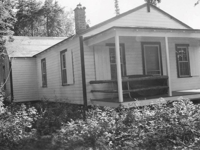 white painted log cabin with open front porch