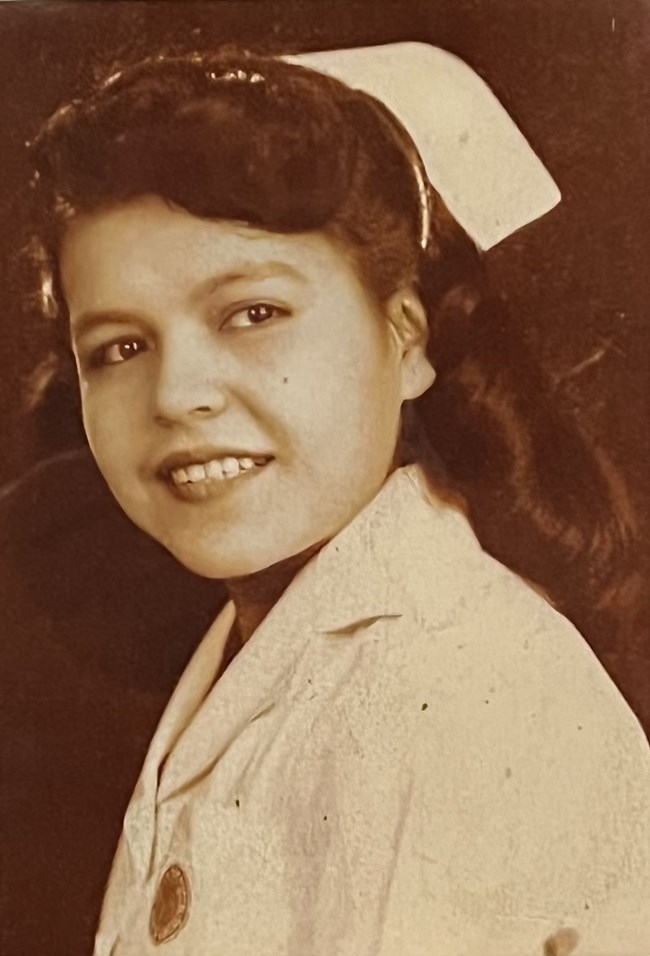 Jo Moss Sepia portrait of a young woman with glossy dark hair in a nursing uniform and cap.