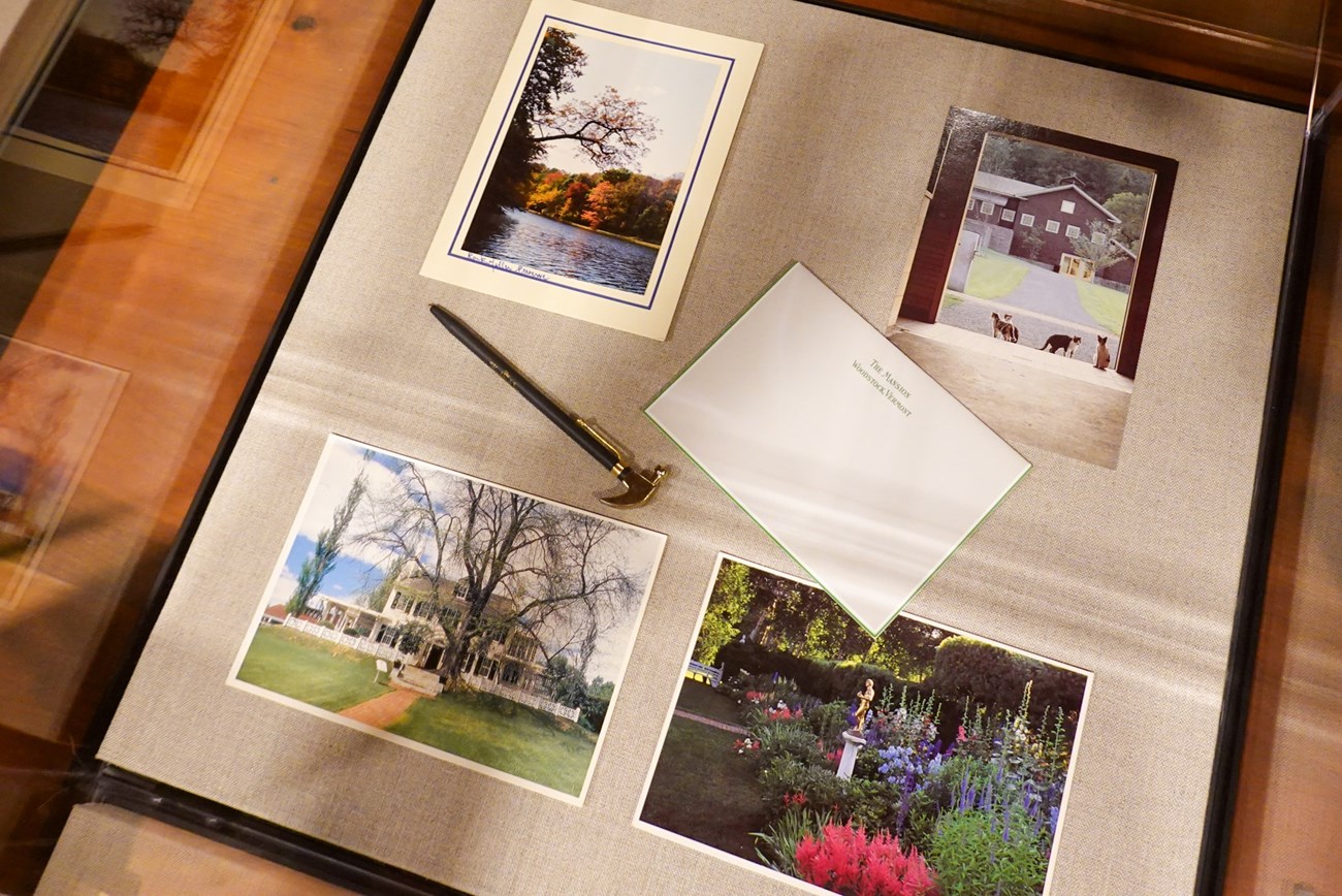 exhibit case with postcards, stationary, and a pen