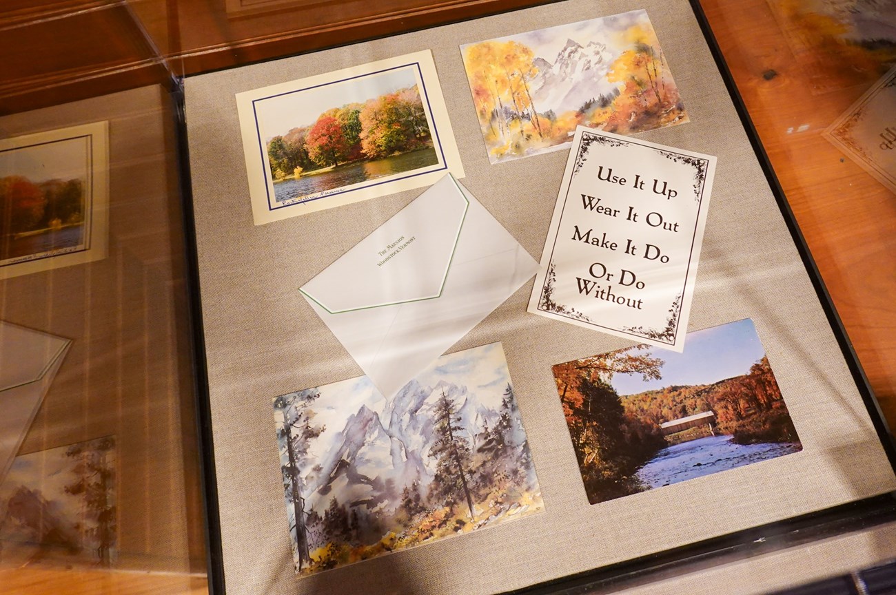 5 post cards and a letter in an exhibit case, one postcard reads "use it up wear it out make it do or do without"