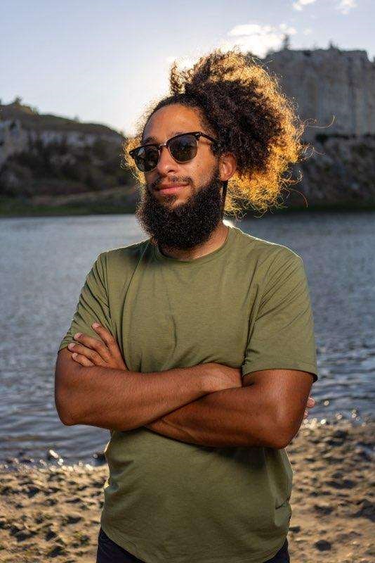 a bearded black man wearing glasses and a bun in his hair