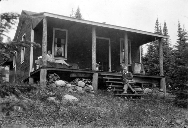 woman reclining on sofa on front porch, man looking on from steps