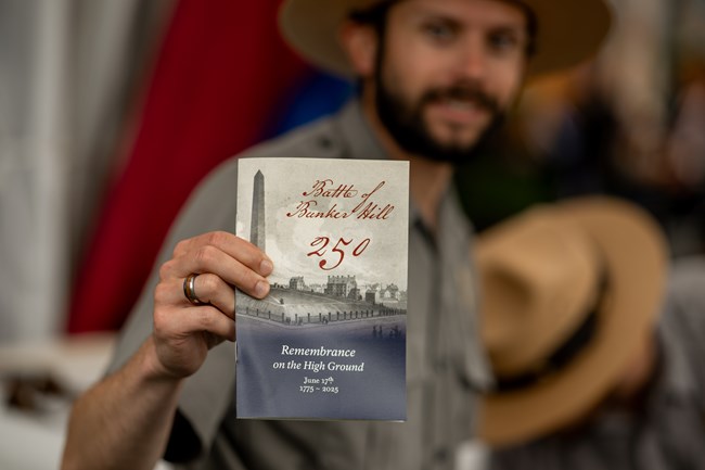 NPS-BattleOfBunkerHill25-454 ranger holding a commemorative booklet for the event.