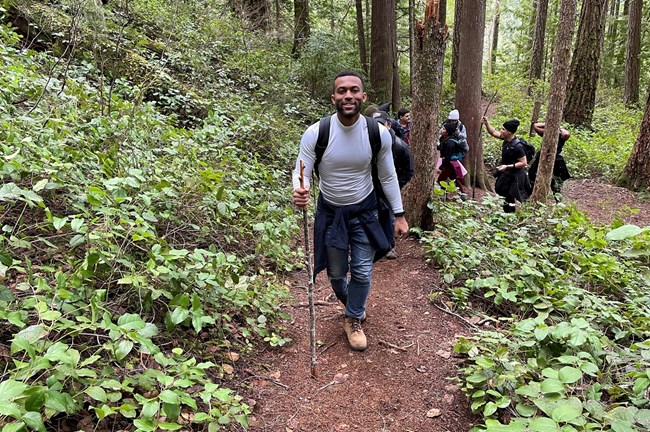 Hiker with a walking stick going down a hill