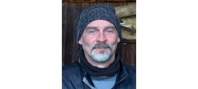 Todd wearing a beanie, a goatee, and a warm vest over a long-sleeved baselayer.