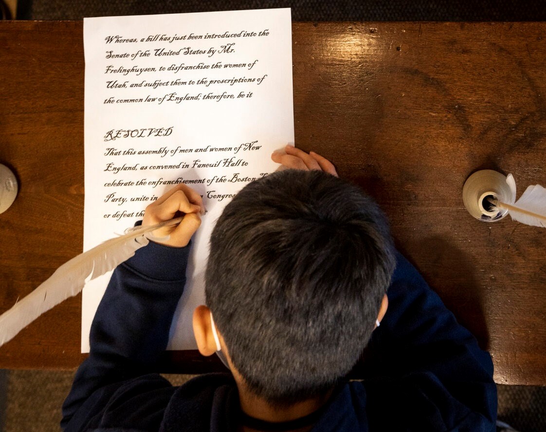 Woman's Tea Party signing A child signing a document with a quill pen