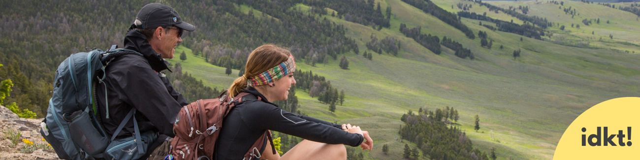 Be Considerate of Others a smiling man and young woman rest on their hike, enjoying the view