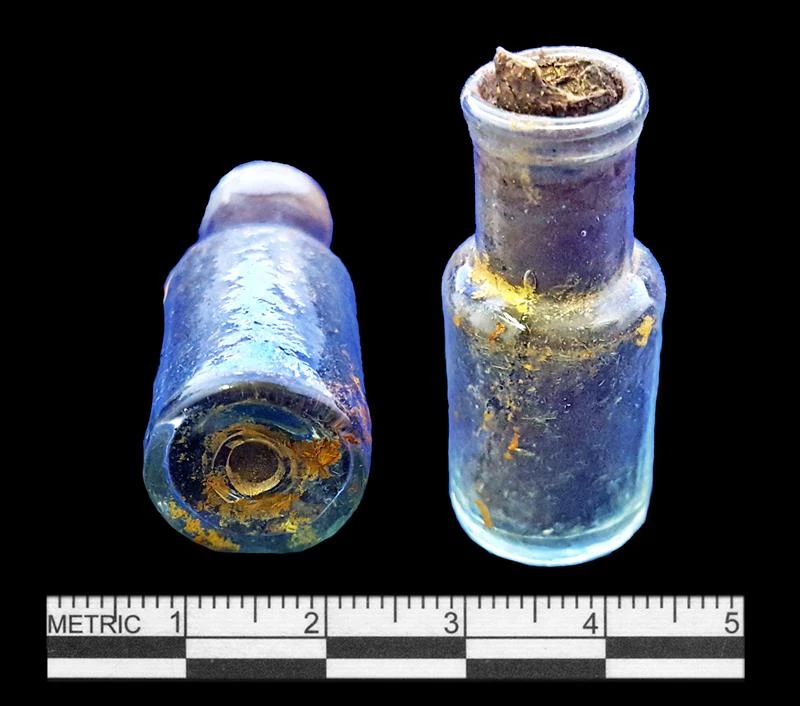 Figure 6. Intact bottle with cork found during excavations. A Small glass bottle closed with a cork found during the excavation. Shown from the side and bottom.