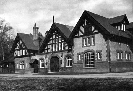 A Queen Anne-style building of three bays constructed in brick and stucco.