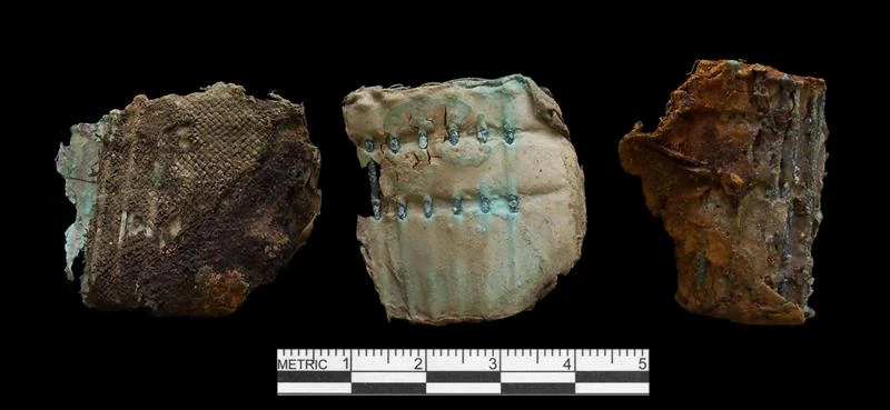Remnants of a pack of straight pins with fabric attached. Remnants of a pack of straight pin and their fabric holder shown from three angles.