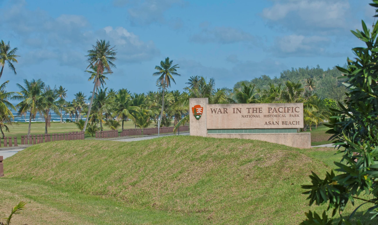 War in the Pacific War in the Pacific National Historic Park welcome sign sits behind a green grassy hill