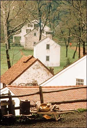 Photo of old stone houses surrounded by trees. National Park Service photo. Photo of old stone houses surrounded by trees. National Park Service photo.