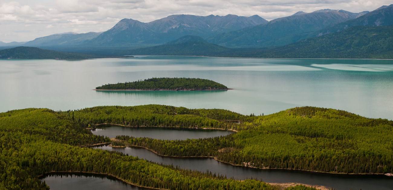 island in lake with mountains beyond