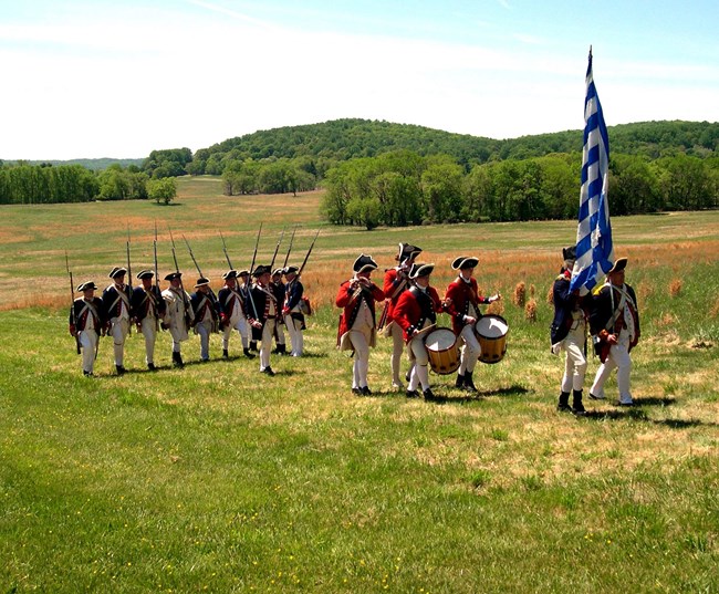 reenactment soldiers marching through meadow