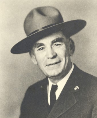 A black and white portrait of a man wearing a park ranger hat.