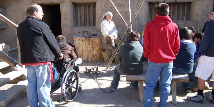 A Park Interpreter, dressed in period clothing as a fort trapper, presenting a program about trapping to visitors