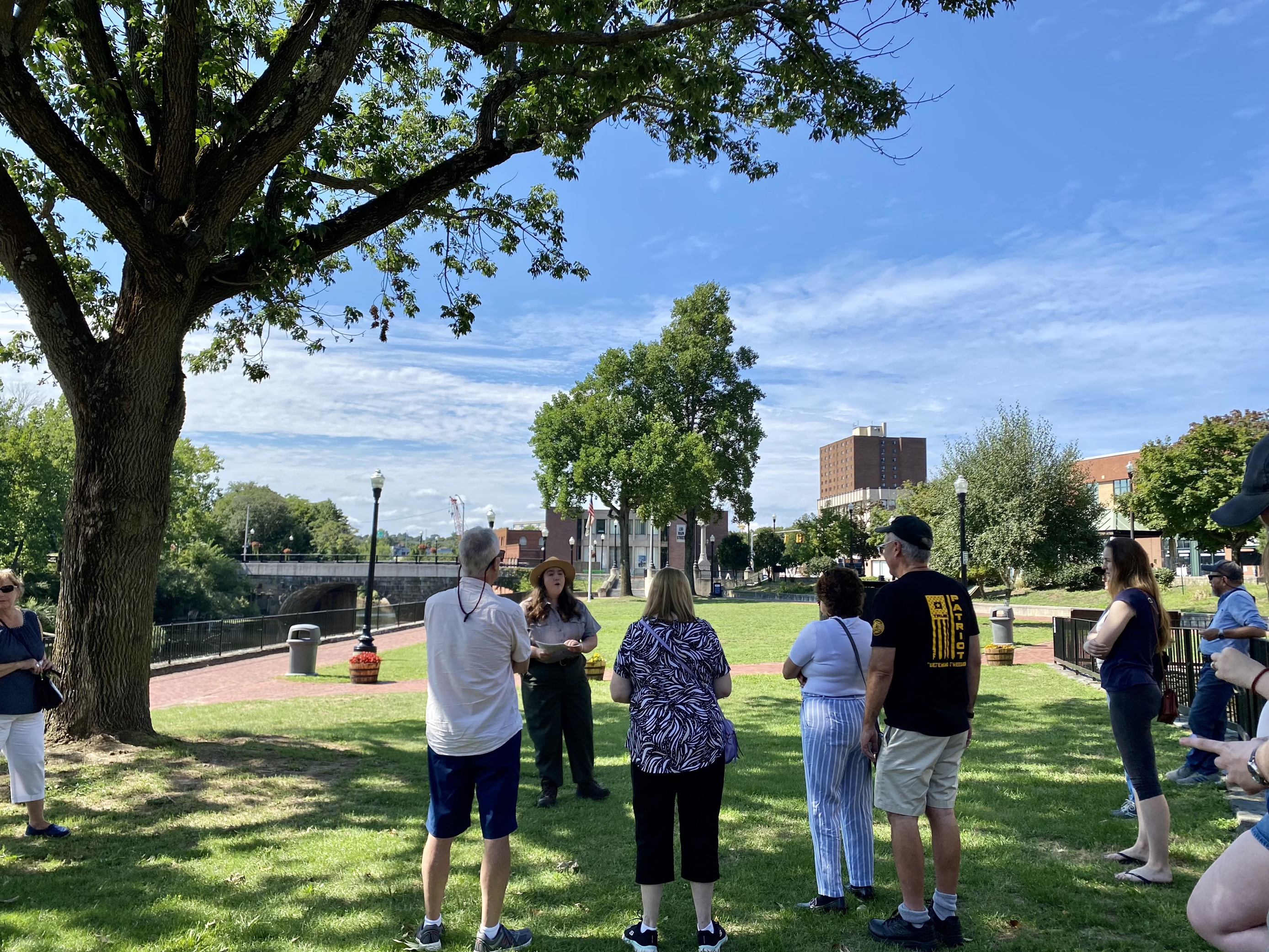 Park Ranger addresses group of visitors alongside Blackstone River