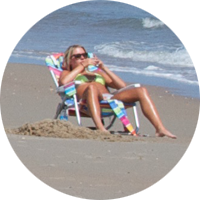 Woman sunbathing down by the ocean at South Beach.