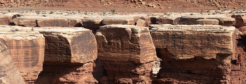 large chunks of white-topped rock sit on top of darker brown rock