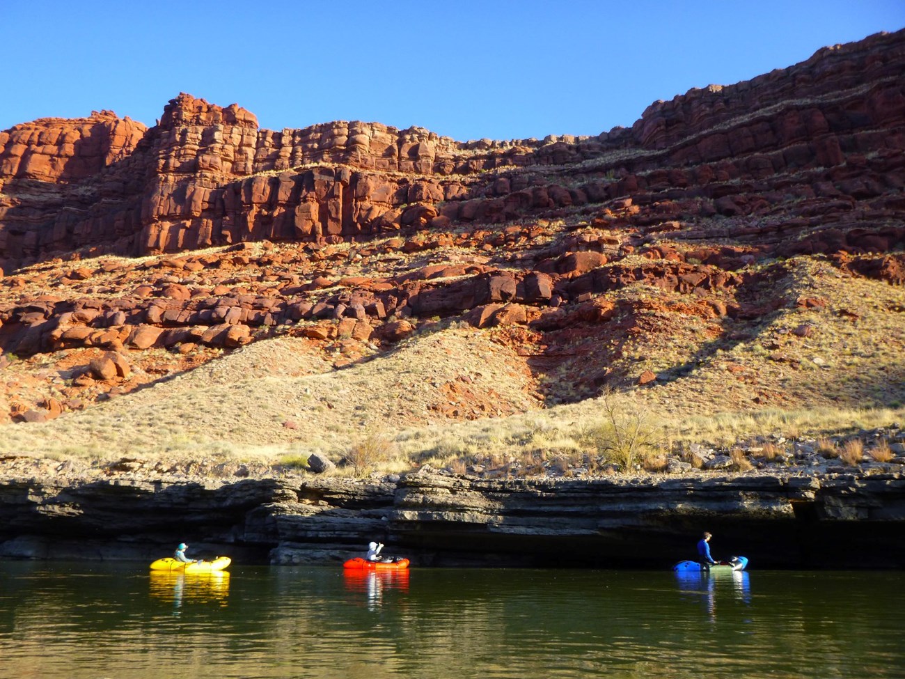 Two boats floating down a river between canyons