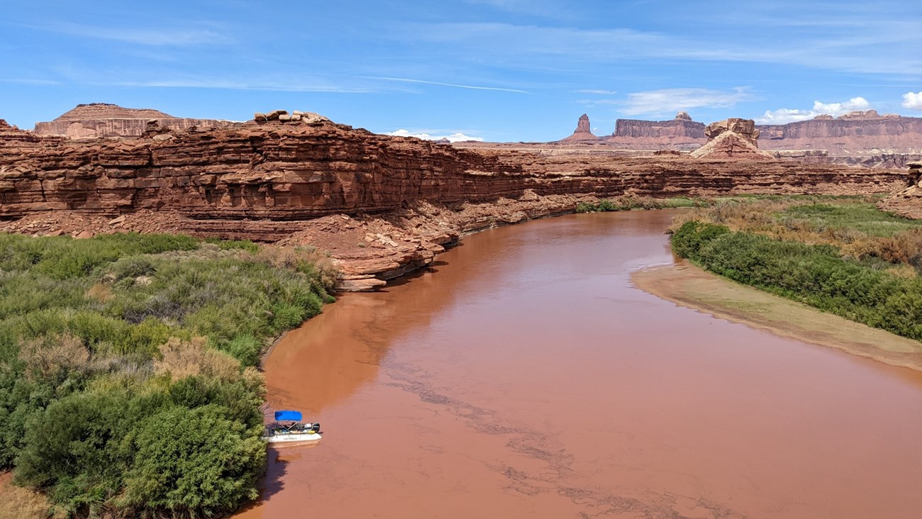 View from above of a white boat parked along a riverbank