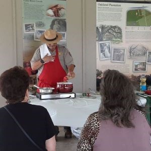 Ranger cooks on a small portable stove while people watch.