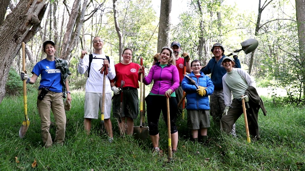 A group of volunteers holding shovels and loppers on National Public Lands Day