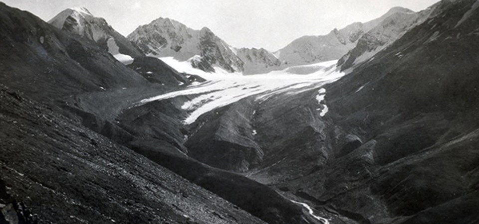 a glacier sits high in a valley