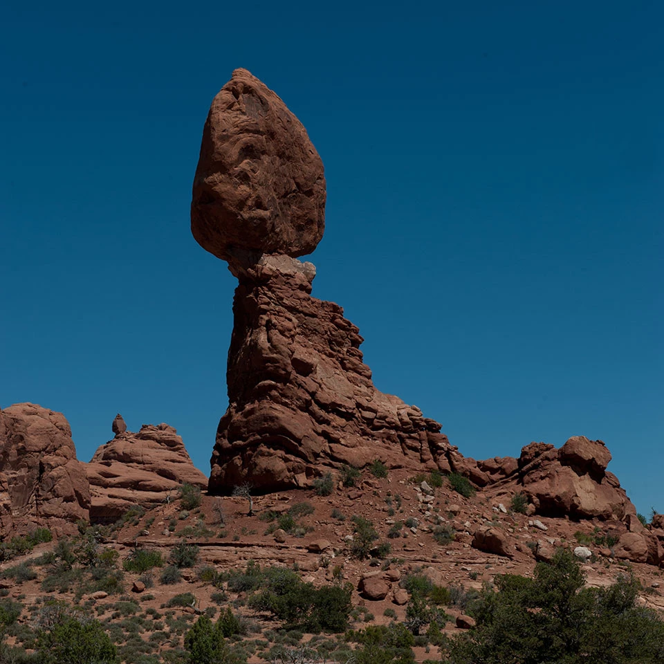 A massive rock perched on a smaller pedestal. A smaller pinnacle stands to the right.