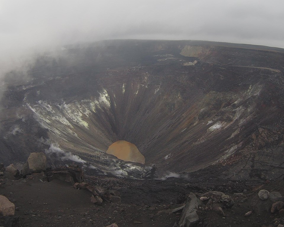 Green lake of water at the bottom of a volcanic crater