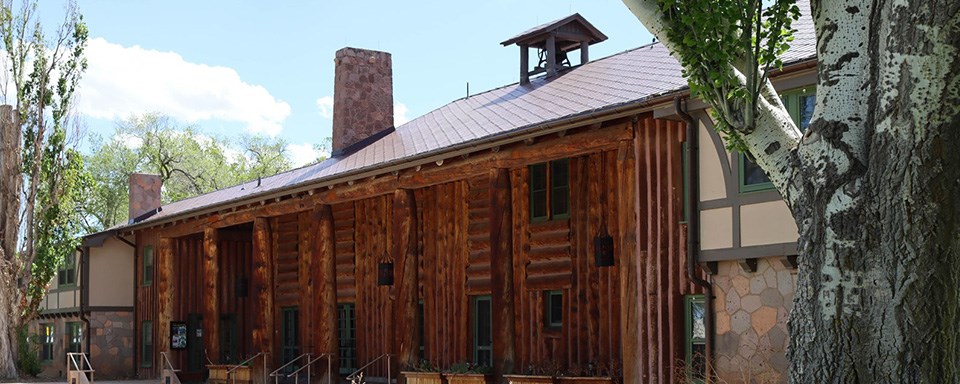 A black and white photo of a lodge made out of logs.