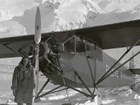 man standing near a small propeller airplane